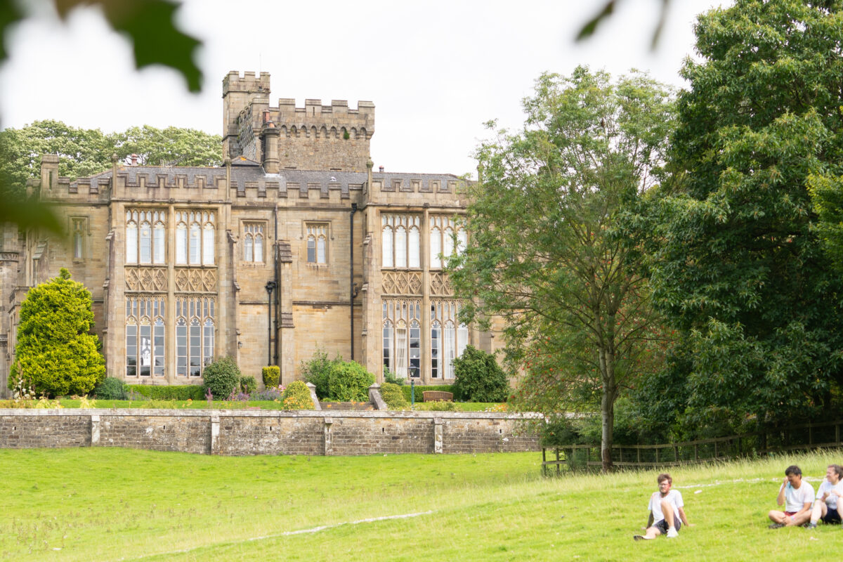 Capernwray house with people relaxing on the lawn in the foreground