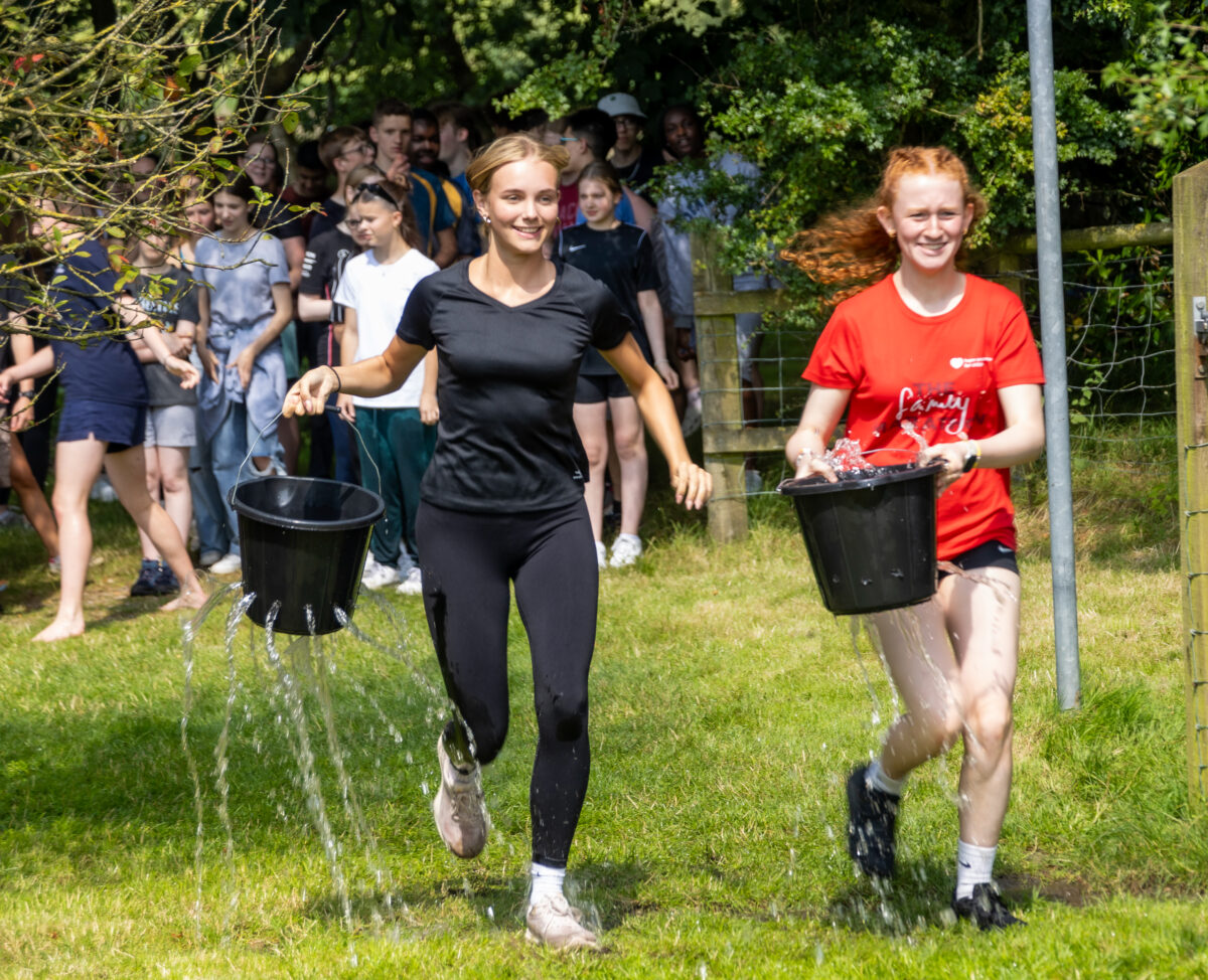 People playing a game with buckets full of holes